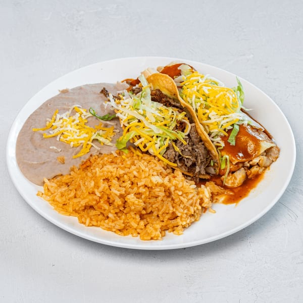Muchas Gracias Mexican Food combo plate with two tacos, rice, and refried beans on a white plate.